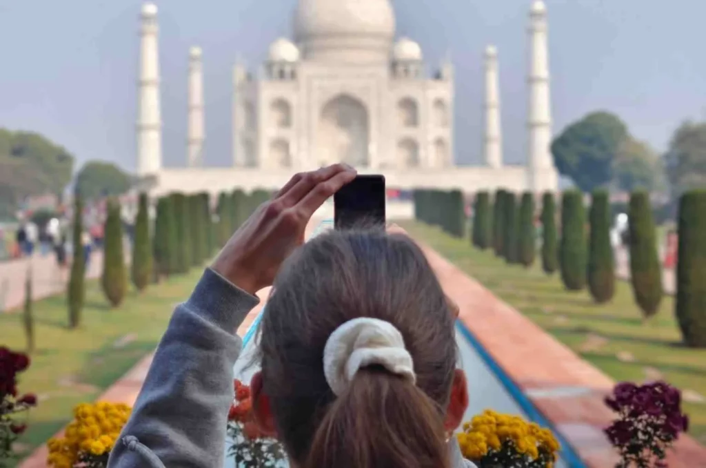 Traveler taking photo of Taj Mahal during one-day Agra tour from Delhi